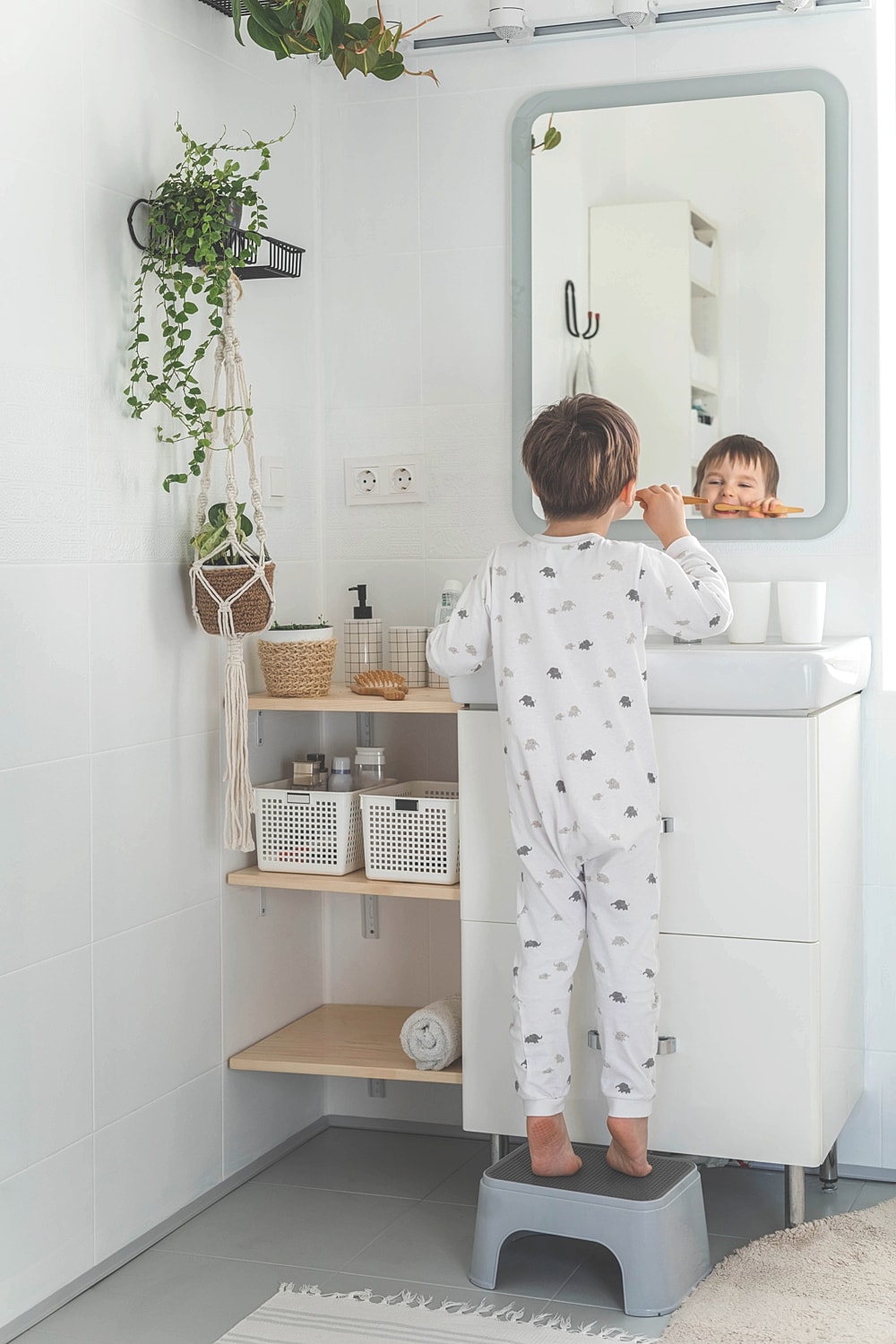 Child brushing teeth in a bright bathroom.