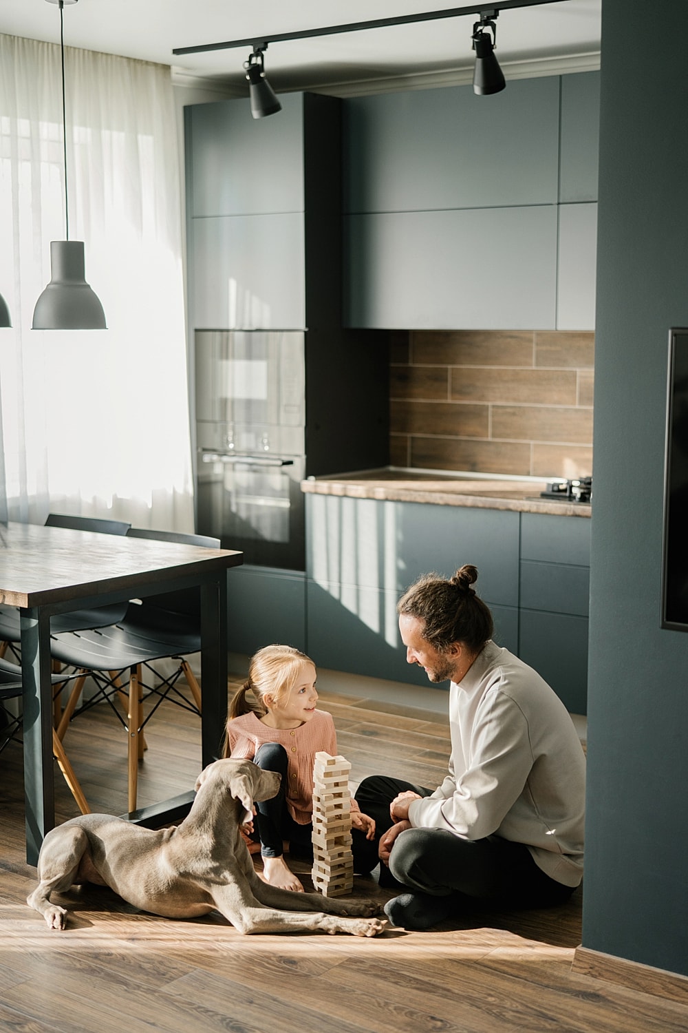 Child and adult playing with blocks and dog.